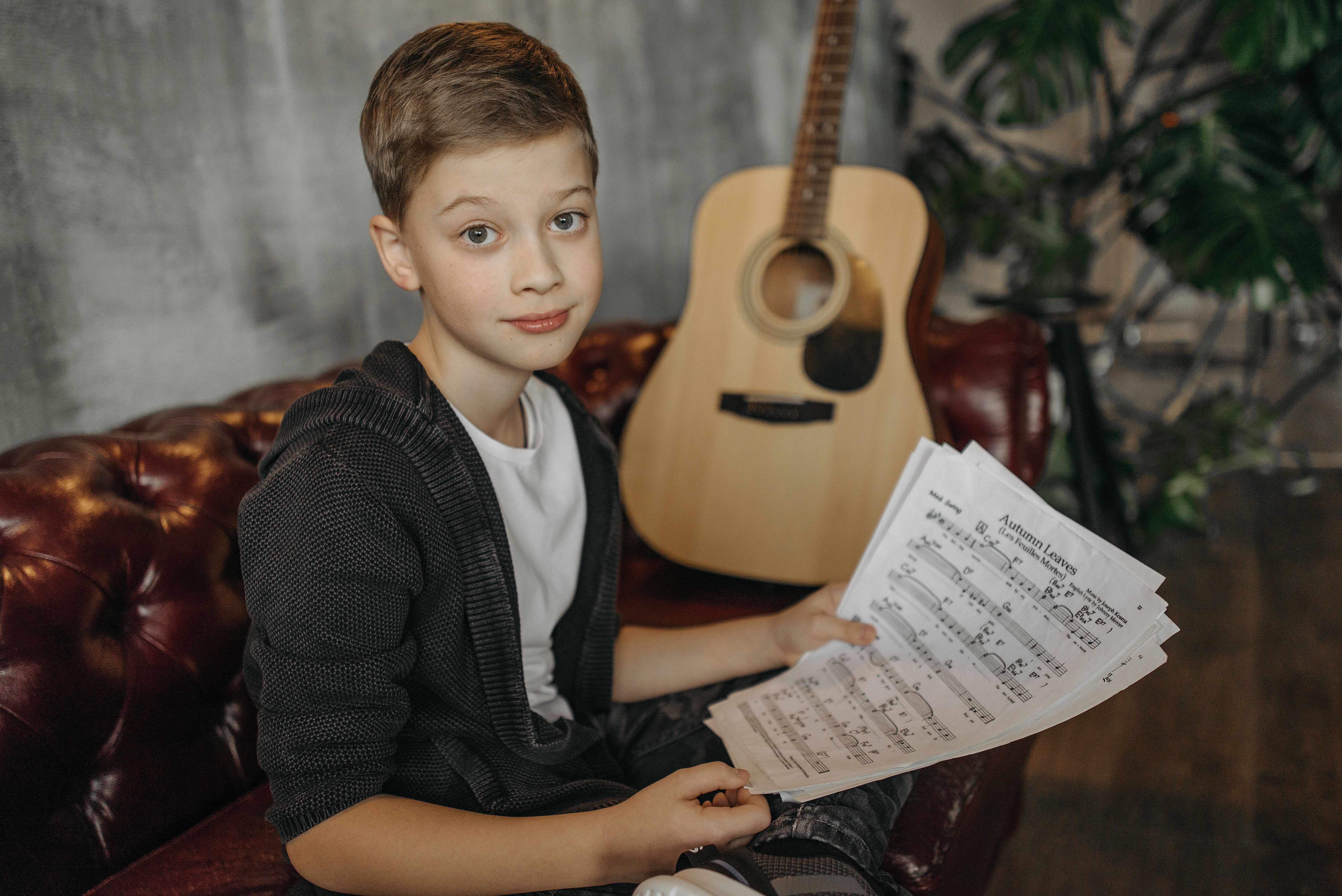 bambino suona la chitarra con lo spartito