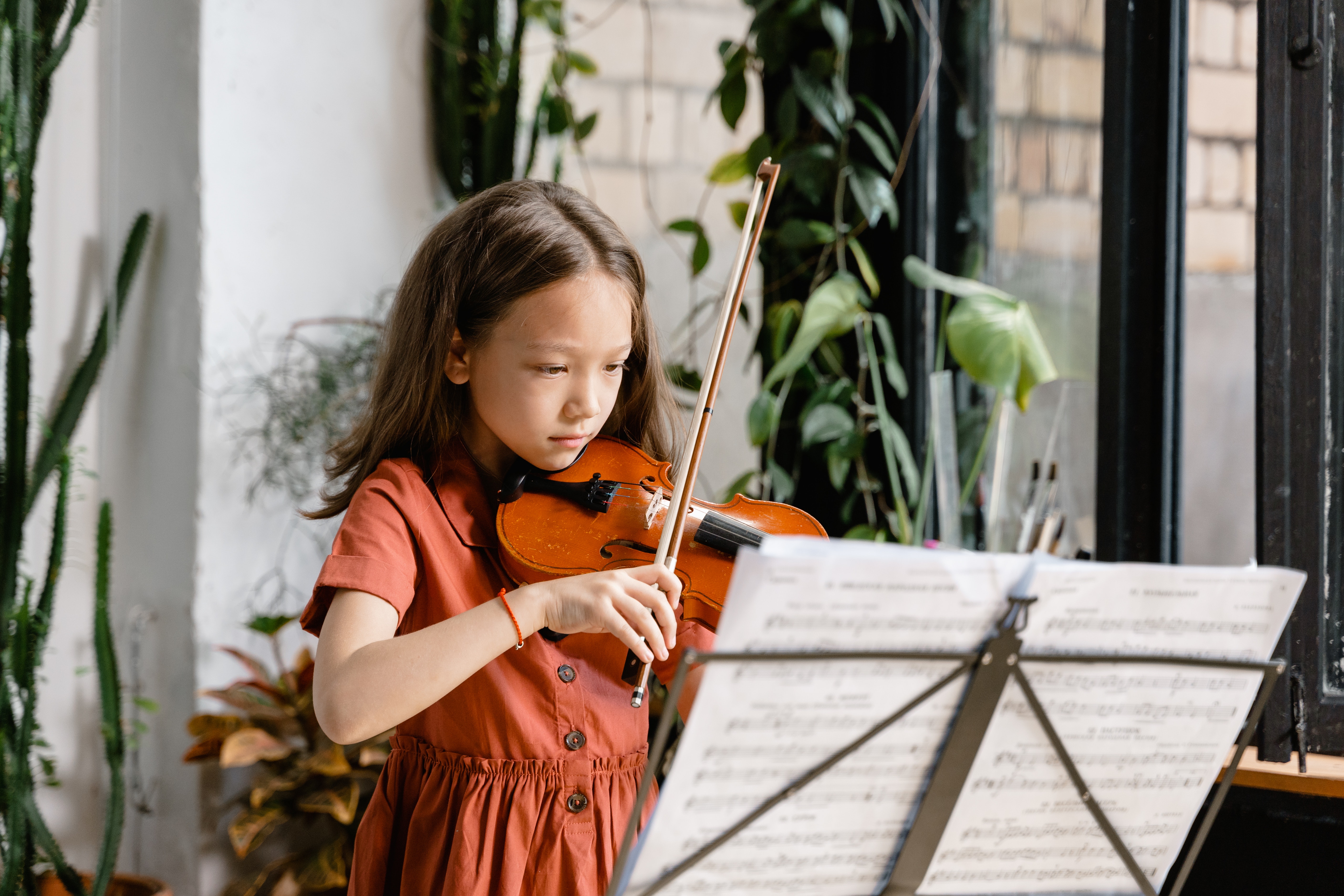 bambina suona il violino con lo spartito